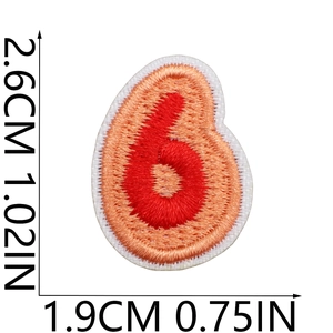 Detail view of orange and red number 6 embroidered patch with white border and measurements