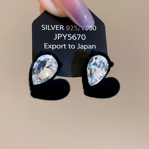 Close-up of S925 silver heart earring with black velvet and teardrop crystal