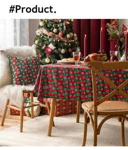 Detail of red and green plaid Christmas table runner with snowflake prints and soft pompoms