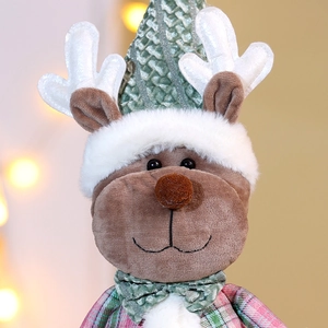 Close-up of a Christmas plush reindeer doll with green knit hat and plaid fabric outfit