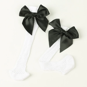Close-up of white mesh knee-high socks with black satin bow accent for girls