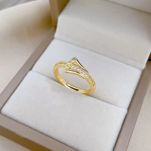 Adjustable gold ginkgo leaf ring with zircon stones shown on a jewelry display box