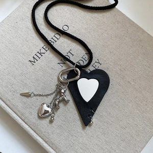 Detail of leather heart puppy pendant necklace with silver chain and metal clasp
