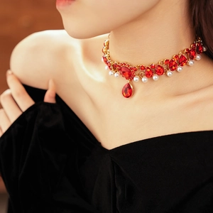 Detail of vintage choker necklace with red rhinestones and pearls on model neck