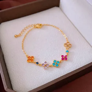 Bracciale placcato oro 18K con cinque fiori colorati in zircone su una scatola regalo