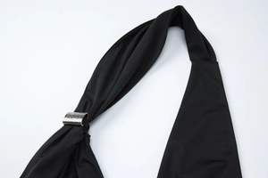 Detailed close-up of black halter top featuring a textured silver metal slider buckle