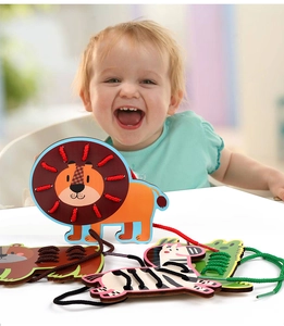 Toddler playing with wooden animal threading board toys including lion and zebra shapes