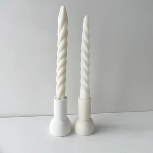 Minimalist spiral textured long pillar candles on cylindrical holders in a clean setting
