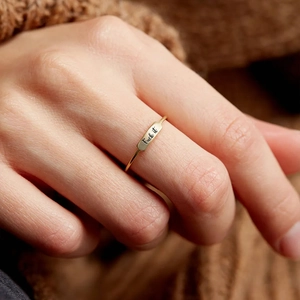 Macro shot of gold engraved S925 silver ring featuring bold text on a minimalist band