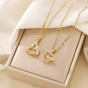 Golden heart wing and fan necklaces with sparkling zircons on elegant beige satin fabric