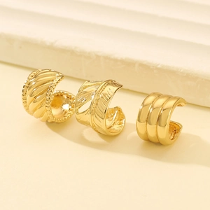 Detail view of gold-plated ear cuffs featuring woven rope and feather texture designs
