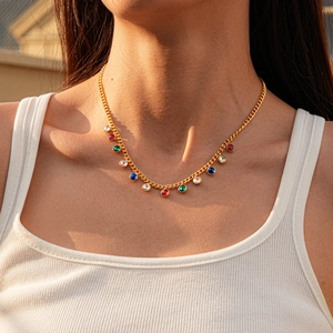 Close-up of gold stainless steel station necklace with colorful round gemstones on model