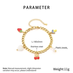 Détail du bracelet à breloques avec pendentifs cerise, fraise et perles en finition dorée