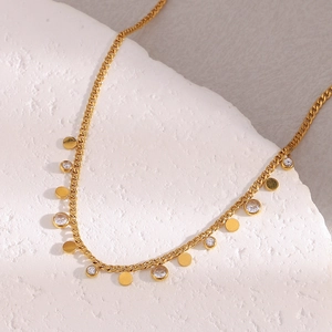 Detail of 18K gold plated necklace featuring round metal discs and sparkling zircons