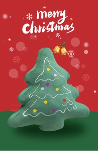 Close-up of soft green plush Christmas tree pillow with colorful embroidery and holiday lights