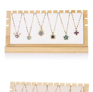 Detailed close-up of various gold necklaces with colorful pendants on a wooden stand