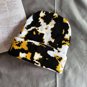 Detail of knit beanie texture with black, white and mustard yellow marble pattern