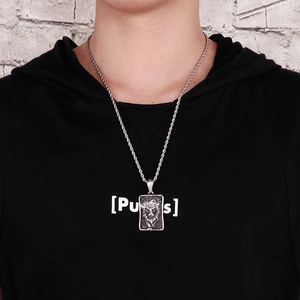 Détail d'un pendentif tête de lion vintage sur une chaîne torsadée argentée sur un homme