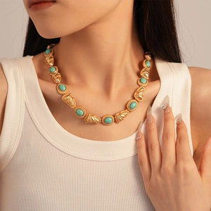 Detailed view of vintage gold necklace with turquoise stones on model neck