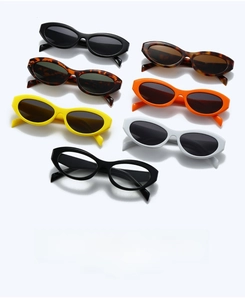 Flat lay of oval sunglasses in multiple colors including black, yellow, and tortoiseshell