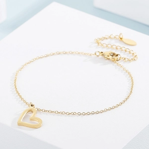 Macro shot of gold heart pendant bracelet with adjustable fine chain and lobster clasp