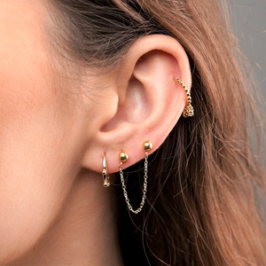 Macro shot of minimalist gold S925 earrings set with bead chain and ear cuff on ear
