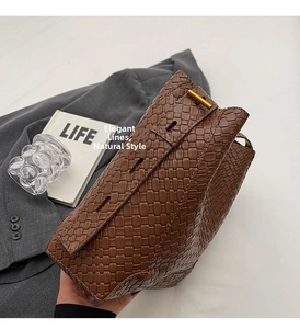Detailed view of brown textured leather tote with golden metallic hardware and sleek lines