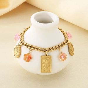 Detailed view of vintage gold charm bracelet with engraved portrait coins and floral beads