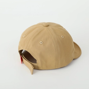 Detail view of khaki cotton baby cap with adjustable velcro strap and red side label