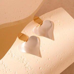 Minimalist bicolor heart earrings with brushed gold and silver metal texture finish