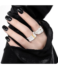 Irregular textured silver rings with gold accents on female model with black nails