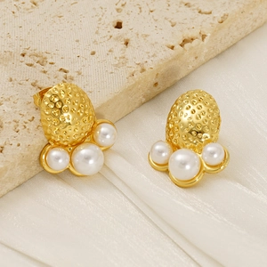 Detail of gold-plated octopus earring with hammered metal and three white pearls