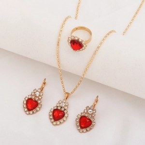 Detailed view of bridal jewelry set with red heart gems and sparkling diamonds on gold finish