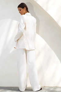 Rear view of white women's pantsuit showing draped fabric and elegant formal fit