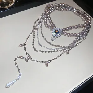 Elegant multi-layer necklace set with pearls, blue gemstone pendant, and star charms