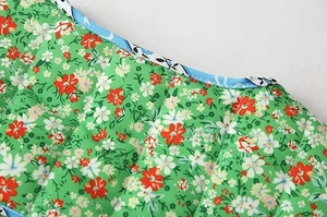 Detail of floral print cotton jacket featuring vertical quilting and contrast piping finish