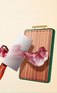 Macro view of ebony wood cutting board with gold handle and raw meat slice