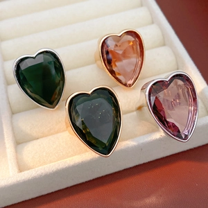 Close-up of heart-shaped zircon rings with faceted crystals in various vibrant colors