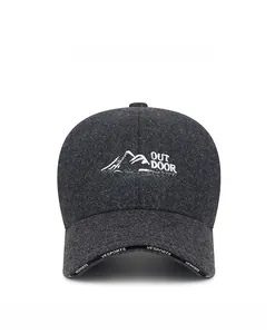 Close-up of wool texture and white mountain embroidery on dark grey baseball cap