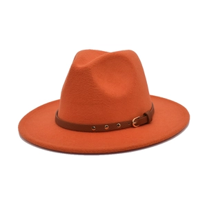 Detailed close-up of orange wool fedora hat featuring a brown leather band and gold buckle