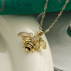 Macro shot of gold bee pendant necklace with zircon wings and black yellow enamel detail