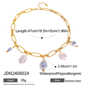 Gold stainless steel necklace with pearl and heart ceramic pendant on white backdrop