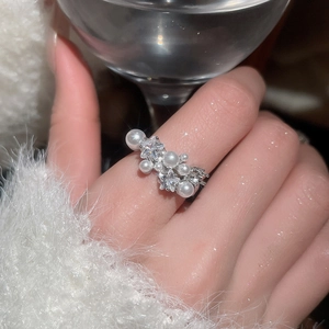 Close-up of elegant silver zircon pearl open ring worn by model with sparkling details