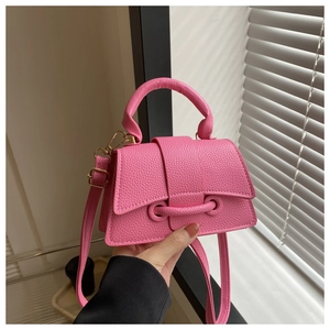 Close-up of pink crossbody bag featuring lychee grain texture and metal ring buckle