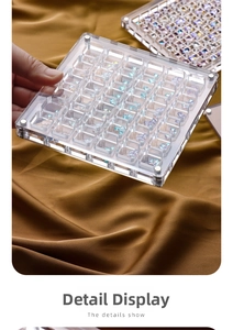 Macro shot of 36-grid clear acrylic nail art box with magnetic clasp and silk background