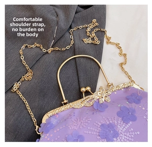 Detail of purple floral embroidery, sequins, and vintage metal kiss lock on evening bag