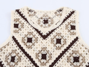 Macro detail of V-neck crochet vest showing intricate granny square patterns and stitching