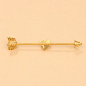 Macro shot of gold arrow piercing heart stud earring with polished metallic finish