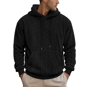 Detailed view of black teddy fleece hoodie with textured floral pattern and kangaroo pocket