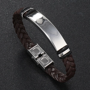 Detailed view of brown braided leather bracelet with a polished stainless steel metal plate